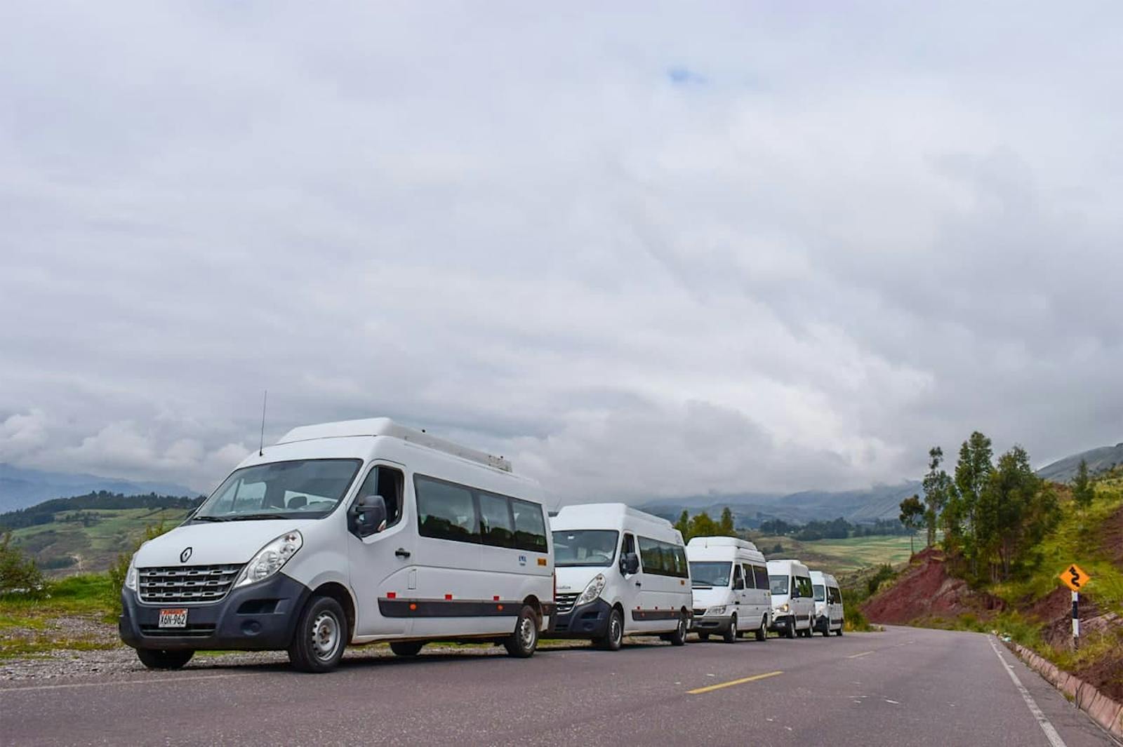 Fehér minibuszok sorai Machu Picchu előtt